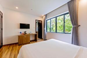 a bedroom with a bed and a large window at Buddy January Villa in Hoi An