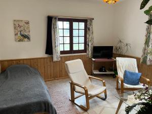 a bedroom with a bed and two chairs and a table at Appartement Ingwer, Floramar in Candelária