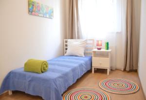 ブダペストにあるTwo Bedroom Apartment at Bajcsyの青いベッドと窓付きの小さなベッドルームが備わります。