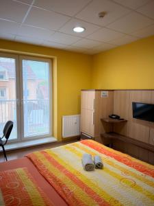 a bedroom with a bed with two slippers on it at Penzion VV SUN - REOS in Hodonín