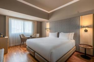 ein Schlafzimmer mit einem großen weißen Bett und einem Tisch in der Unterkunft AC Hotel A Coruña by Marriott in A Coruña + 55 Fotos