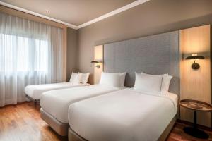 ein Hotelzimmer mit zwei Betten und einem Fenster in der Unterkunft AC Hotel A Coruña by Marriott in A Coruña