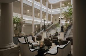 a lobby with chairs and tables and stairs at Badischer Hof Baden-Baden - Leonardo Limited Edition in Baden-Baden