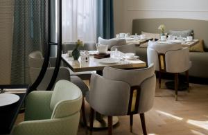 a restaurant with tables and chairs in a room at Badischer Hof Baden-Baden - Leonardo Limited Edition in Baden-Baden +40 photos