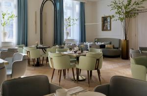 a restaurant with tables and chairs and a couch at Badischer Hof Baden-Baden - Leonardo Limited Edition in Baden-Baden