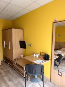 a desk in a room with a yellow wall at Penzion VV SUN - REOS in Hodonín
