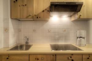 a kitchen with a sink and a coffee maker at Residence Dolomieu in San Cassiano