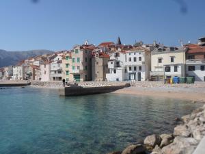a group of buildings on the shore of a body of water at Apartment IVANKA -KROK in Baška