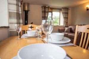 a dining room table with wine glasses on it at Lake View - Old Mill Cottages in Ilfracombe