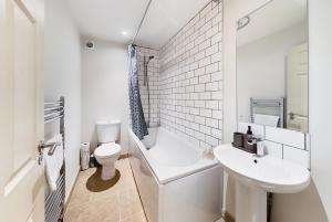 a white bathroom with a toilet and a sink at Redhill town centre apartments by Livingo in Redhill