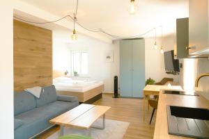 a living room with a blue couch and a bedroom at Geidorf Residenz - Serviced Apartments & Parking in Graz