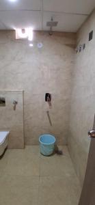 a bathroom with a bucket in the corner of a shower at Hotel Silver Oak in Dehradun +26 photos