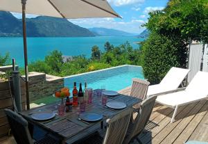 a table with wine bottles on a deck with a pool at Tiny-Pool-Lake in Viviers-du-Lac