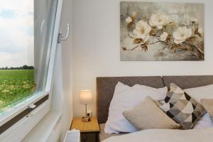 a bedroom with a bed and a window with a flower painting at Rotkäppchen in Dörverden