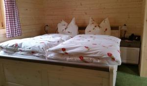 a bed with white blankets and pillows on it at Landgasthof Gänsberg in Wiesloch