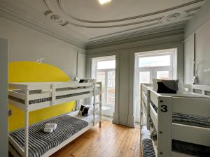 a room with two bunk beds and two windows at A Beira Hostel in Aveiro