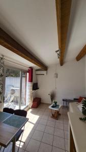 a kitchen and living room with a table and chairs at Les Cigalines très proche village natu in Cap d'Agde