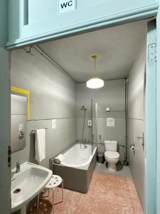 a bathroom with a tub and a sink and a toilet at A Beira Hostel in Aveiro +120 photos