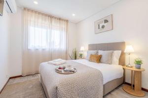 a bedroom with a bed with a tray on it at Bright & Spacious Flat with Balcony by HostWise in São Mamede de Infesta