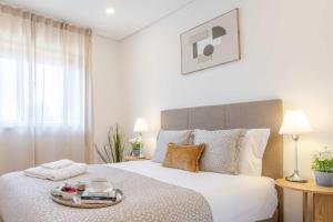 a bedroom with a bed with a tray on it at Bright & Spacious Flat with Balcony by HostWise in São Mamede de Infesta