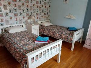 a bedroom with two beds and a wall with pictures at Sleeps10-PrivatePool-GamesRoom-GatedGardens in Paizay-le-Chapt +30 photos