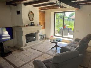 a living room with a couch and a fireplace at Sleeps10-PrivatePool-GamesRoom-GatedGardens in Paizay-le-Chapt
