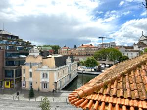 a view of a city with a river and buildings at A Beira Hostel in Aveiro