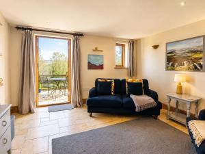 a living room with a blue couch and a window at Pretty Wood Cottage Quiet Cottage in Private Meadow in Eyam