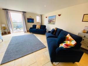 a living room with a blue couch and a rug at Pretty Wood Cottage Quiet Cottage in Private Meadow in Eyam +44 photos