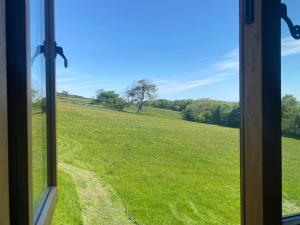 a view of a field from a window at Riley Wood Cottage Peaceful Cottage, Views & Walks in Eyam