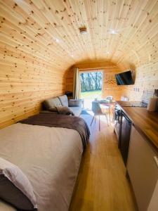 a room with a large bed in a wooden house at Kestrel Cabin Quiet Woodland Cabin & Nature in Eyam