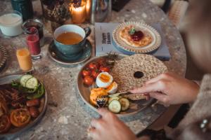 a table with a plate of food and a person eating food at Quality Hotel Waterfront in Ålesund