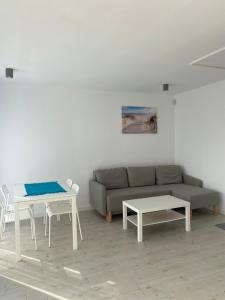 a living room with a couch and two tables at Wisełka Apartamenty Sea & Lake in Wisełka