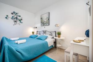 a bedroom with a blue bed and a table at Hvar Villa Maris in Hvar