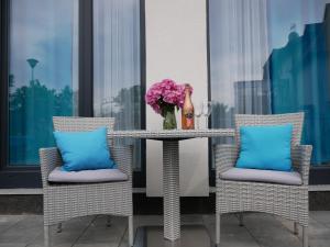 a table with a vase of flowers and two chairs at Wisełka Apartamenty Sea & Lake in Wisełka