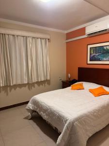 a bedroom with a bed with orange pillows on it at Sol Del Sur Hotel in Huaquillas