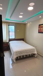 a bedroom with a bed with a white comforter at Sol Del Sur Hotel in Huaquillas