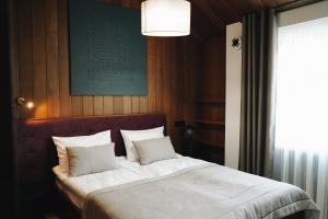 a bedroom with a bed with white sheets and pillows at Камінь in Ostrovets +62 photos