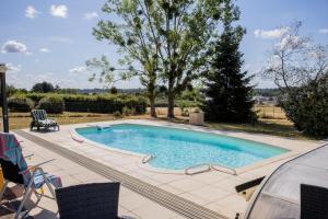 a swimming pool in a yard with a table and chairs at Clos Sainte Anne avec piscine in Cour-Cheverny