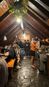a group of people in a kitchen preparing food at Alaska Patagonia Hostel in San Carlos de Bariloche