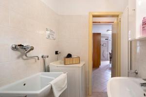 a bathroom with a bath tub and a sink at Casa Heidi in Castello Tesino