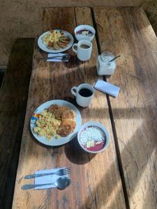 a table with plates of food and cups of coffee at Jungle Cabin - Satori Natural in Puerto Nariño +51 photos