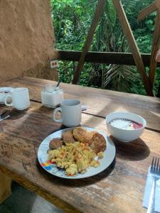 a plate of breakfast food on a wooden table at Jungle Cabin - Satori Natural in Puerto Nariño