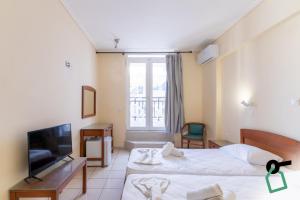 a hotel room with two beds and a flat screen tv at Hotiday Zakynthos Argassi in Zakynthos