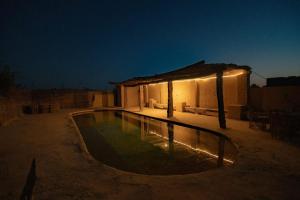 a house with a swimming pool at night at Ayur Lodge Siwa Oasis in Siwa