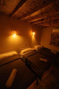 two beds in a room with lights on the wall at Ayur Lodge Siwa Oasis in Siwa