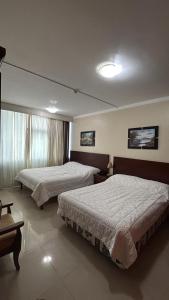 a hotel room with two beds and a window at Sol Del Sur Hotel in Huaquillas