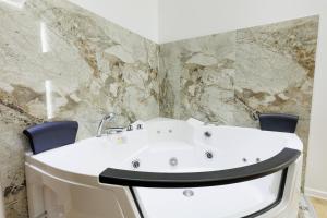a bathroom with a white sink and two chairs at Aqua Apartments 1 in Jagodina +34 photos