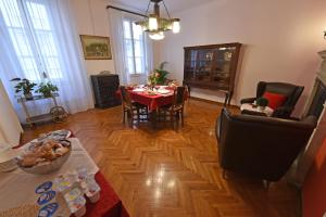 a living room with a table and a dining room at B&B Al Giardino Leonor in Trieste