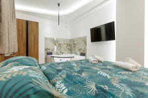 a bedroom with a bed with a blue comforter at Aqua Apartments 1 in Jagodina